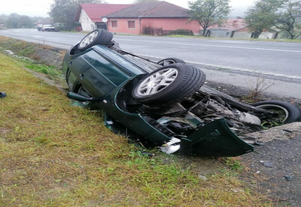 Mașină răsturnată cu roțile în sus, oameni răniți
